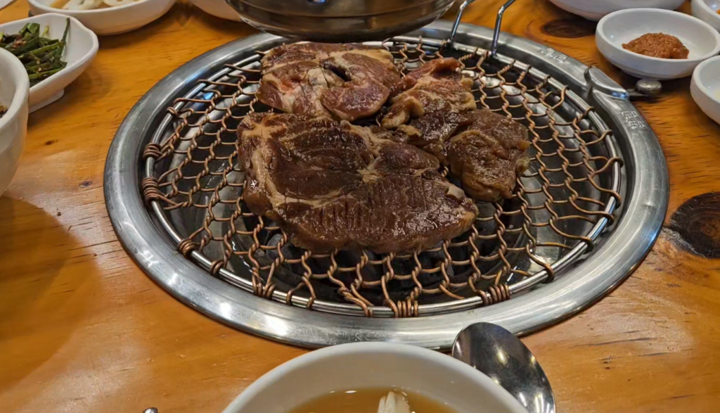 Korean dwaeji galbi pork ribs grilling over charcoal