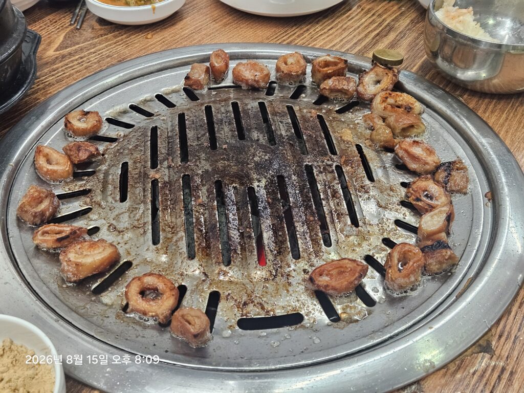 Grilled meat, soju, and side dishes during a Korean dinner