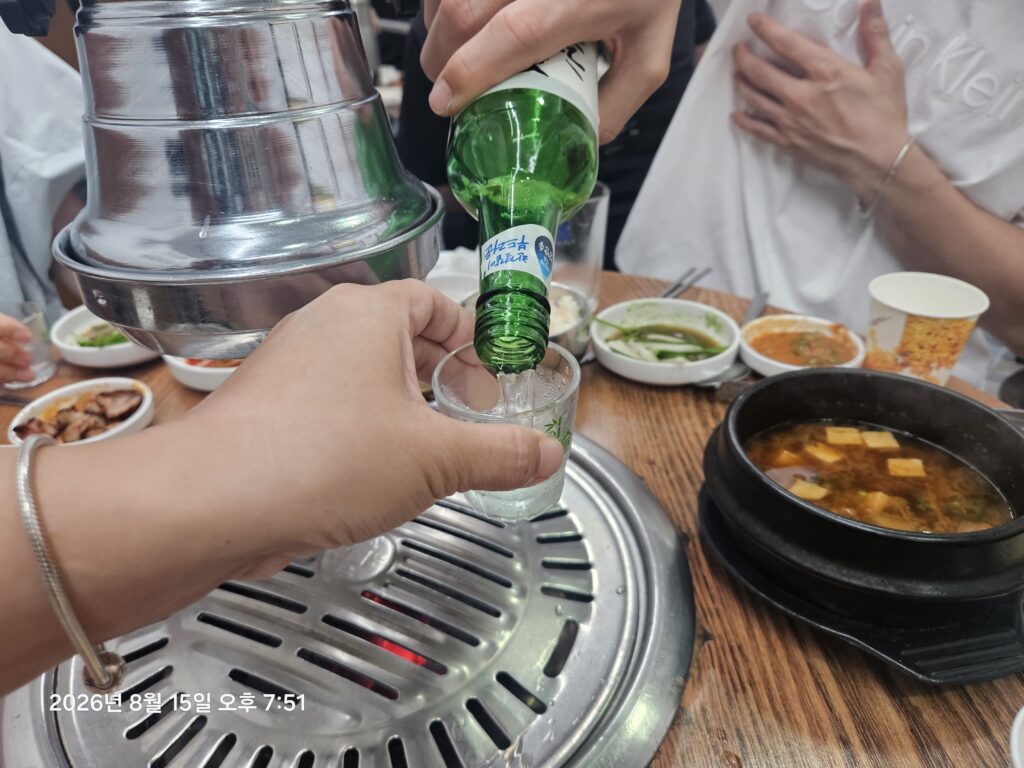Soju being poured during a Korean dinner with friends