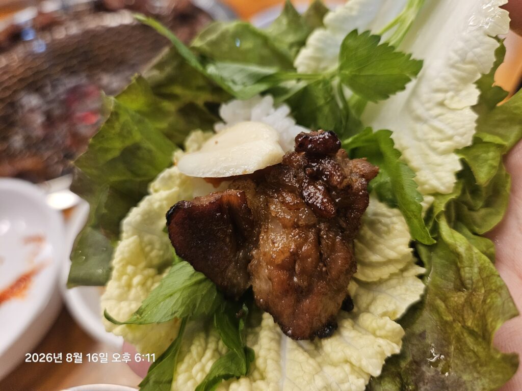 Grilled Korean pork galbi wrapped with fresh vegetables and garlic